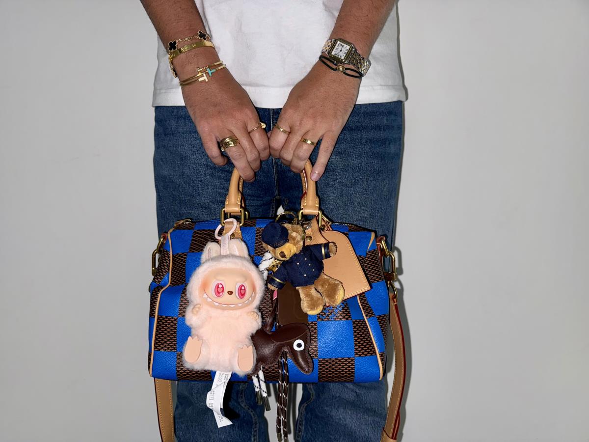 Muškarac drži torbu sa Labubu priveskom