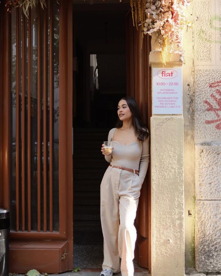 Dženi Martin pozira u skalinama sa pićem