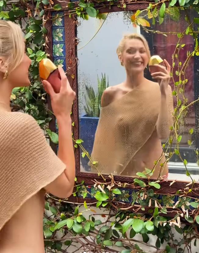 Bela Hadid u zlatnom poluprovidnom šalu i gingham pantalonama promoviše parfem Eternal Roots