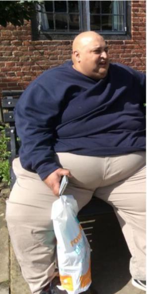 Harvi Olik sedi na klupi sa kesom u ruci.jpg