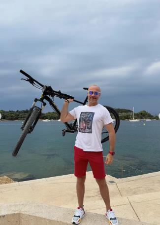 Aleksandar Sofronijević drži bicikl u ruci