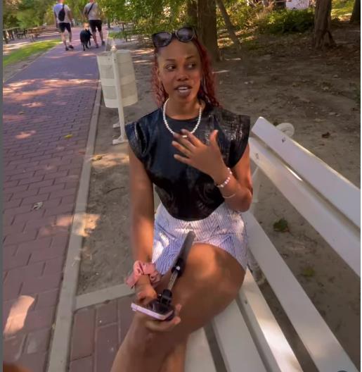 Džulijana Abasa sedi na klupi u parku.jpg