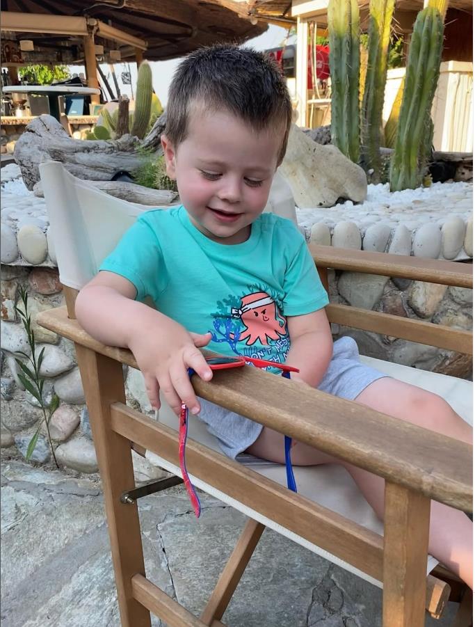 Bili Tompson u plavoj majici sedi na stolici.jpg