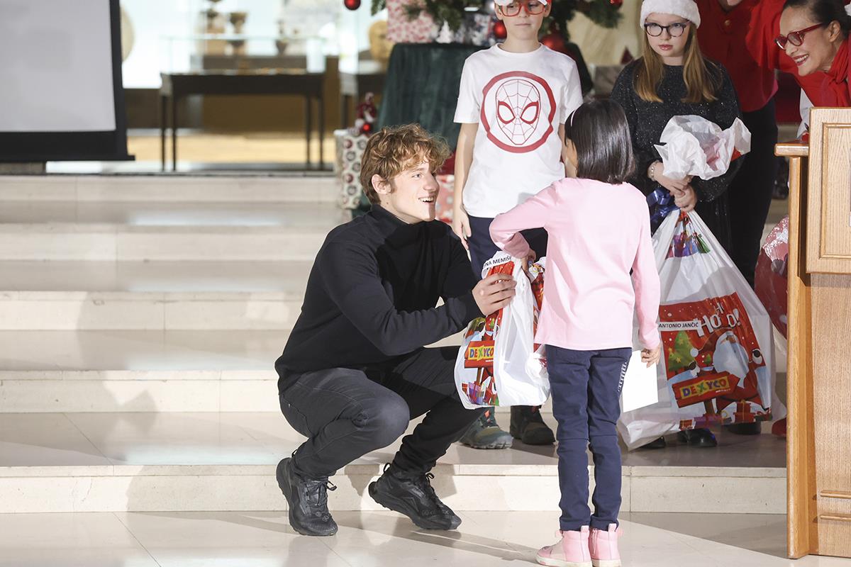 Luka Grbic dodeljuje poklon detetu iz Prihvatilišta.jpg