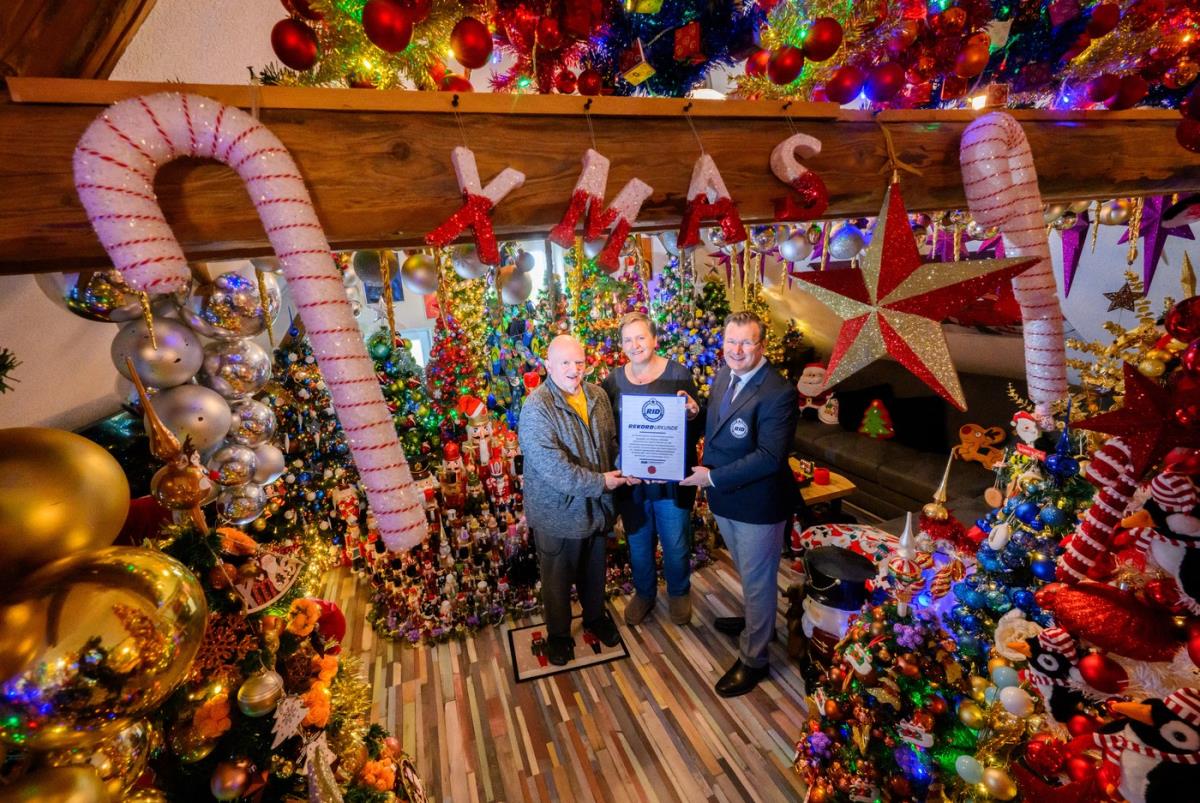 Unutrašnjost kuće sa desetinama okićenih božićnih jelki prepunih lampica