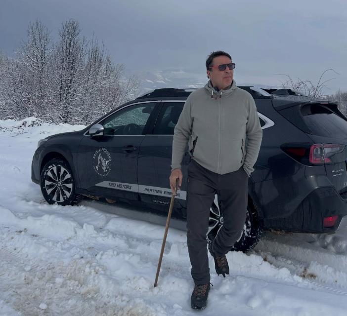 Jovan Memedović pored automobila, oko njega sneg i šiblje