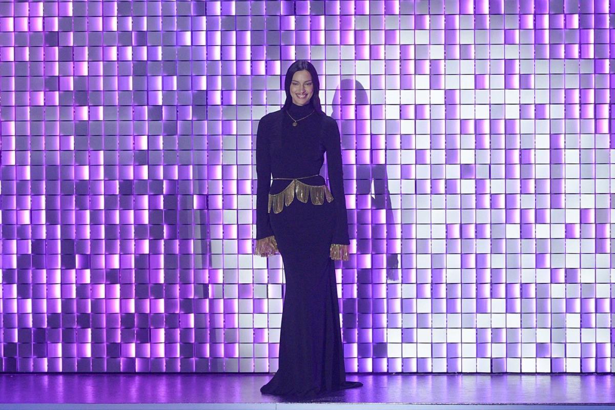 Irina Šajk nosi crnu haljinu sa visokom kragnom i potpuno otvorenim leđima