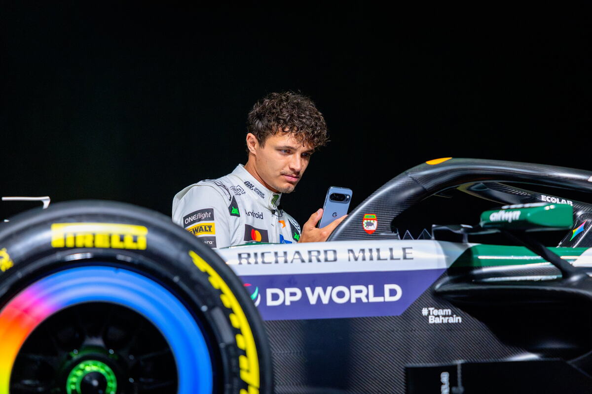 Lando Noris pored bolida Meklarena u belim bojama za trku u Silverstonu