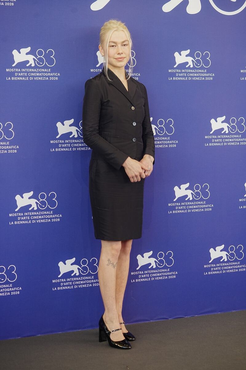 Fibi Bridžers na 83. Venecijanskom filmskom festivalu u crnom kompletu sa vidljivim prirodnim dlačicama na nogama