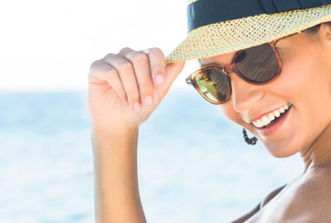 stockphotoportraitofsmilingyoungwomanwearingsunglassesandpanama255827206.jpg