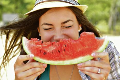 stockphotohappyyoungwomaneatingwatermelononthebeachyouthlifestylehappinessjoyholidaybeach322923848.jpg