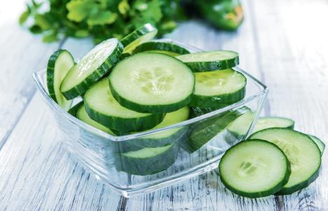 stockphotoheapoffreshslicedcucumbersonanoldwoodentable297523988.jpg