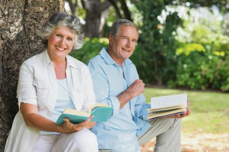 stockphotosmilingmaturecouplereadingbookstogetherinparklookingatcamera148291250.jpg