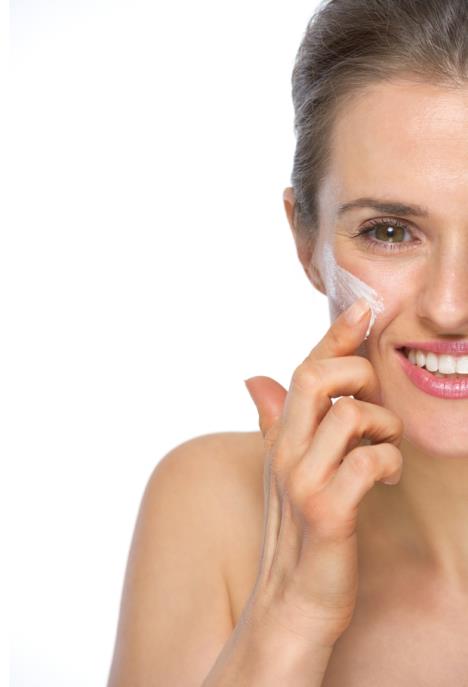 stockphotocloseuponhappyyoungwomanapplyingcreme194749256.jpg