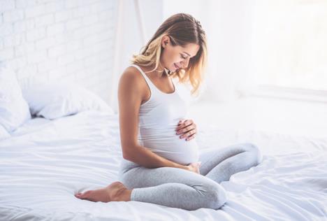 stockphotoattractivepregnantwomanissittinginbedandholdingherbellylastmonthsofpregnancy727852972.jpg