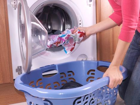 Žena ubacuje veš u mašinu
