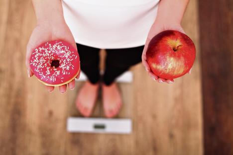 stockphotodietwomanmeasuringbodyweightonweighingscaleholdingdonutandapplesweetsareunhealthy543917185.jpg