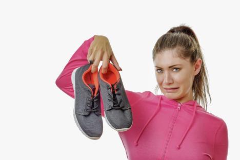 stockphotofitnesswomanholdinguphersmellyexerciseshoes725552512.jpg