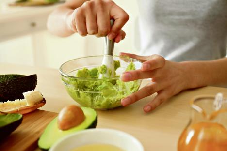 stockphotowomanmakingnourishingmaskwithavocadoinkitchen1108218389.jpg