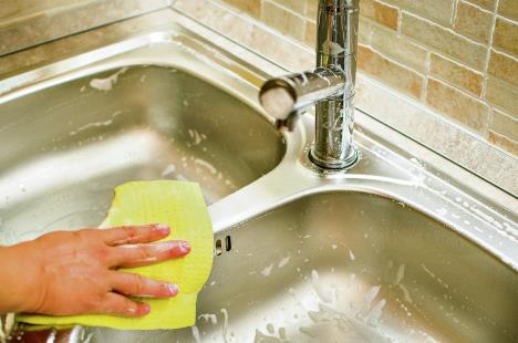 stockphotowomanhanddoingchoresinthekitchenathomecleaningsinkandfaucetwithayellowsponge308156990.jpg