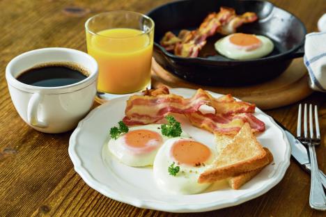 stockphotoamericanbreakfastwithsunnysideupeggsbacontoastpancakescoffeeandjuicewood530324440.jpg