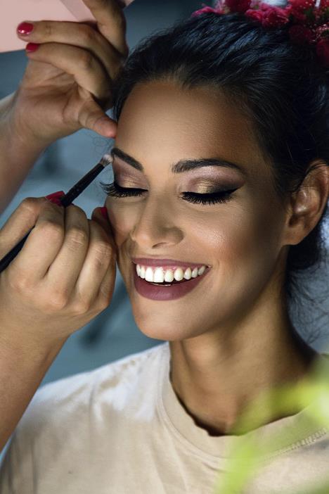 stockphotobeautifulbrunettedoinghermakeupindressingroom714420862.jpg