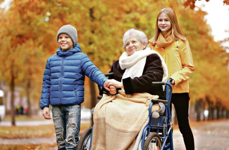 stockphotocutechildrenwiththeirelderlygrandmotherinwheelchairoutdoorsonautumnday772463683.jpg