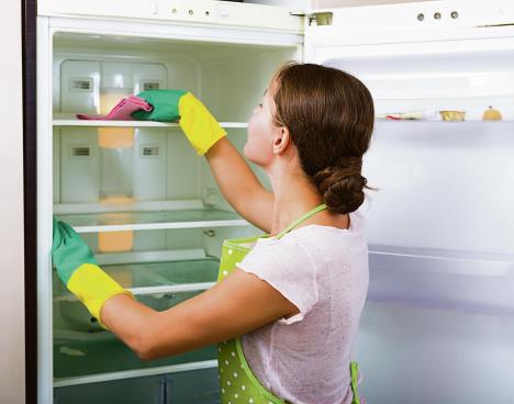 stockphotoadulthousewifecleaningrefrigeratorinsideandsmiling340364804.jpg