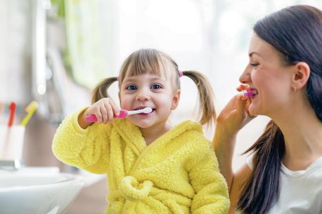 stockphotobeautifulmotherandkiddaughterbrushingteethinbathroom1019069908.jpg