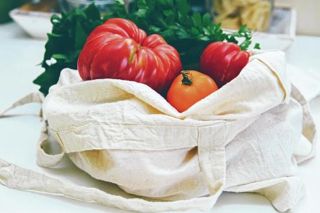 stockphotoreusablecanvasgrocerybagwithredandyellowtomatoesandspinachlocalmarketvegetables1154319595.jpg