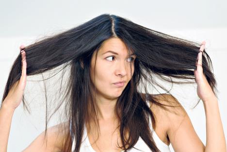 stockphotoattractiveyoungwomanunhappywiththeconditionherlonghairstandinggrimacingatthecamera164685002.jpg