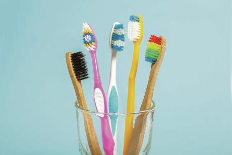 stockphotosetoftoothbrushesinglassonbluebackgroundconcepttoothbrushselectionbambooecofriendly1204882069.jpg