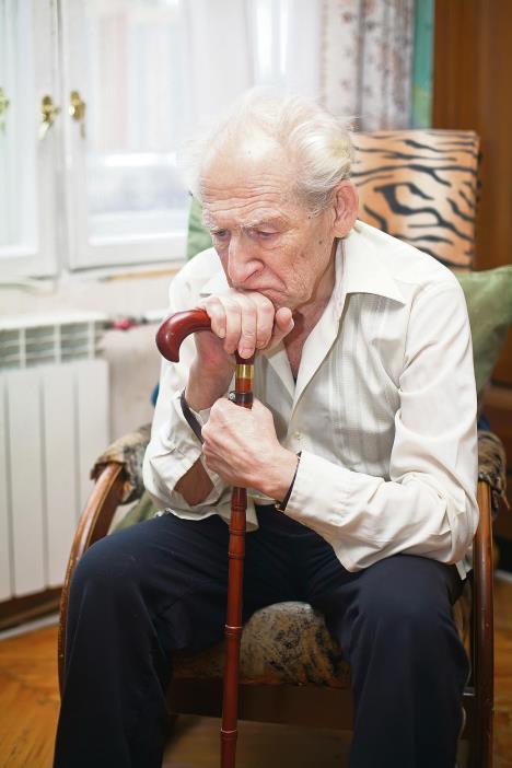 stockphotosadlonelyoldmansittinginanarmchairwithhiscane95707429.jpg