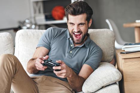 stockphotothatismybestroundexcitedyounghandsomemanplayingvideogameandkeepingmouthopenwhile379851964.jpg