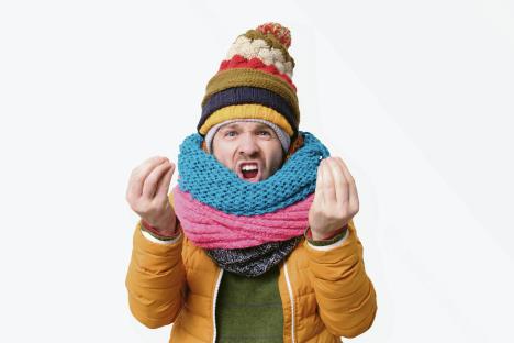 stockphotohandsomemaninseveralhatsandscarfslookingangryshowingitaliangestureoverwhitebackground1560221261.jpg