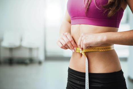 stockphotoslimyoungwomanmeasuringherthinwaistwithatapemeasurecloseup301460216.jpg