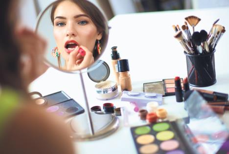 stockphotoyoungbeautifulwomanmakingmakeupnearmirrorsittingatthedesk284658365.jpg