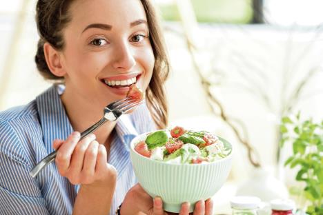 stockphotocloseupofawomaneatinghealthysaladwithtomatoescherryindoors622381877.jpg