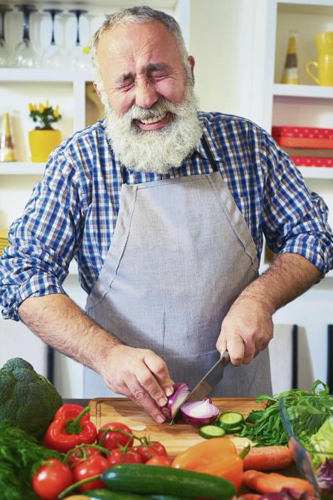 stockphotocloseupofmaturemanchoppinganonionstingingeyesandtearswhencuttingonionstoprepare593949683.jpg