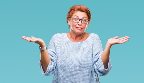 stockphotoatrractiveseniorcaucasianredheadwomanwearingglassesoverisolatedbackgroundcluelessand1242294583.jpg