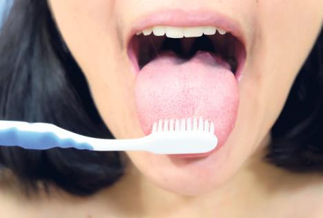 stockphotowomancleaningtongueusingtoothbrush689104408.jpg