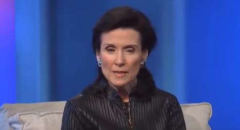 Merilin vos Savant u crnoj košulji sedi na krevetu naslonjena na jastuk