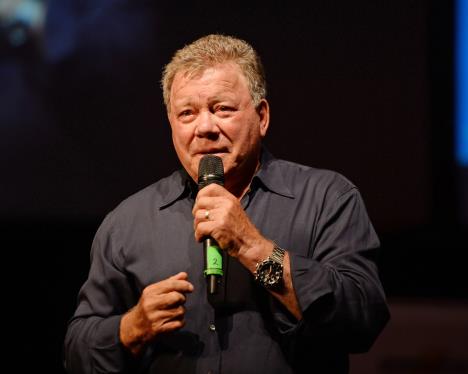 Vilijam Šatner u sivoj košulji drži govor