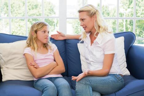 stockphotowomanexplaininglittlegirlwhilesittingonsofaathome183774191.jpg