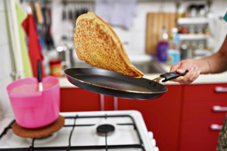 stockphotowomanflippingpancakeinthefryingpanwithdexterity1509105416.jpg