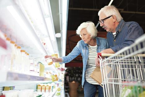 stockphotosideviewportraitofmodernseniorcouplechoosingmilkproductsstandingbydairyislein1006605355.jpg