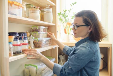 stockphotointeriorofwoodenpantrywithproductsforcookingadultwomantakingkitchenwareandfoodfrom1438546592.jpg