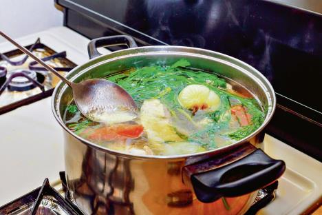 stockphotohomemadepreparingchickensoupwithvegetablesinmetalpanbrothwithherbs1545067667.jpg