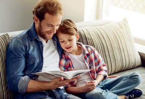 stockphotofatherandsonarereadingabookandsmilingwhilespendingtimetogetherathome523948348.jpg