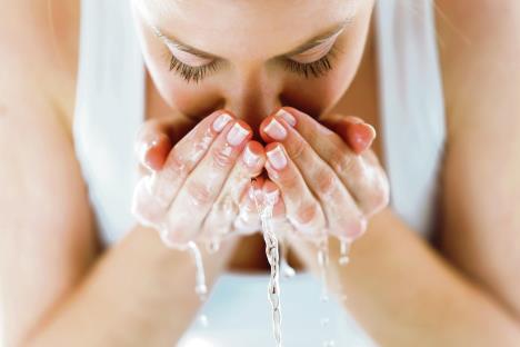 stockphotoportraitofbeautifulyoungwomanwashingherfacesplashingwaterinahomebathroom1170991717.jpg